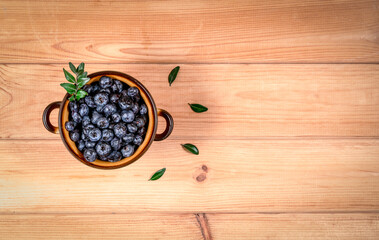 blueberries in a plate on a wooden background