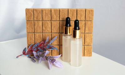 Two bottles with pipettes on a brown background. Serum, essential oils or liquid collagen, skin...
