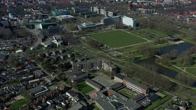 Aerial top view of a city in Holland, surrounded by houses, green trees and canal