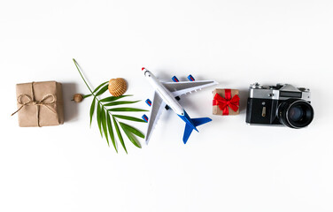 Summer banner with a camera, a palm leaf, an airplane, shells, a gift on a white background.