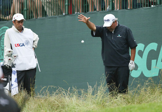 Argentina's Angel Cabrera drops his ball near the 17th green during the weather delayed first round of the 2013 U.S. Open golf championship at the Merion Golf Club in Ardmore