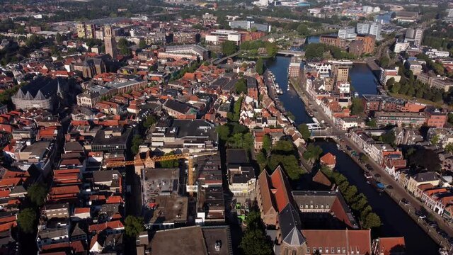 Aerial top view of a city in Holland, surrounded by houses, green trees and canal