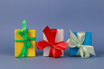 Three multicolored gift boxes on blue background.