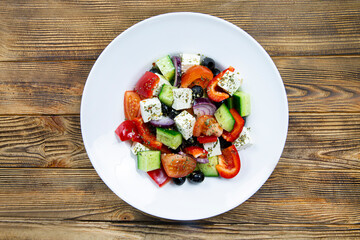 Fresh tasty greek salad on rustic wooden background, top view. 