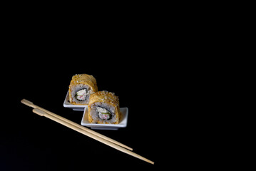 Sushi on white saucers two pieces roll chopsticks