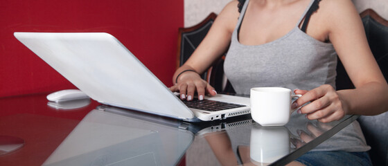 Woman using white laptop computer at home.