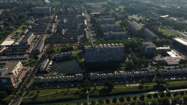 Aerial top view of a city in Holland, surrounded by houses, green trees and canal