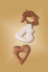 Gingerbread cookies in white and brown glaze fly on a beige background