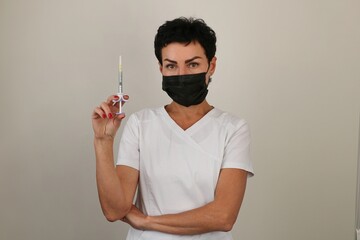 Beautician showing a syringe for lip augmentation with a filler