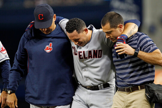 Cleveland Indians Asdrubal Cabrera is helped off the field by manager Terry Francona and a trainer after injuring himself running to first base at Yankee Stadium in New York