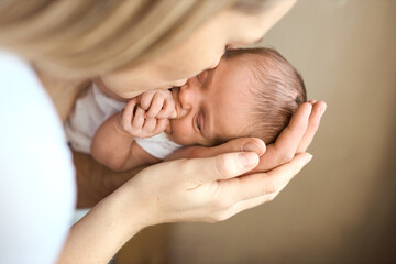 Close-up portrait of happy young father hugging and kissing his sweet adorable newborn child. I