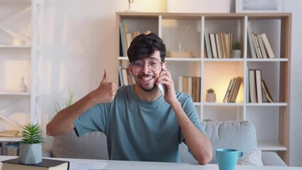 Happy phone call. Mobile surprise. Success celebration. Impressed excited satisfied winner guy showing wow reaction thumb up gesture at light home office interior.