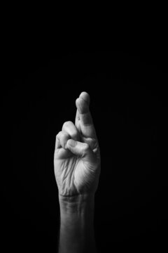 B+W image of hand demonstrating Chinese sign language letter X isolated against black background