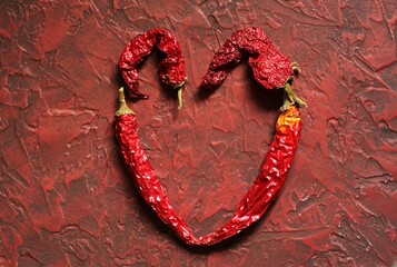 heart of hot chili peppers on a red background. copy space. place for text.