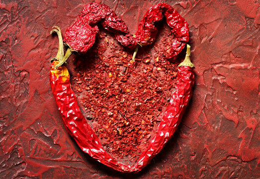 heart of hot chili peppers on a red background. copy space. place for text.
