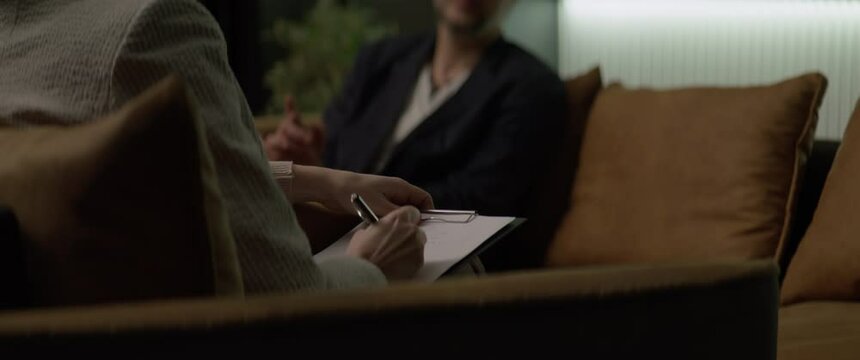 CU Psychologist making notes during an appointment with a client. Shot with 2x anamorphic lens