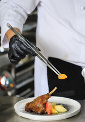 Chef Preparing Dish In Kitchen. Decorating Dish.