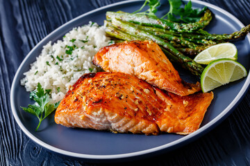 fried salmon fish fillet with rice and asparagus - obrazy, fototapety, plakaty