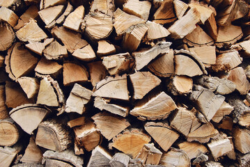 Stacked chopped dried logs texture as background