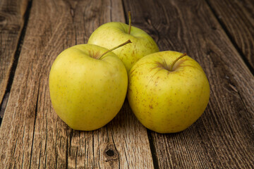 GOLDEN yellow apples on a wooden background.The fruit is fresh.