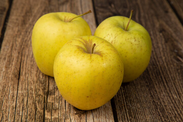 GOLDEN yellow apples on a wooden background.The fruit is fresh.