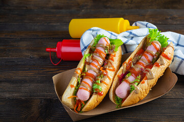 Delicious hot dog with ketchup and mustard on wooden background. Street food