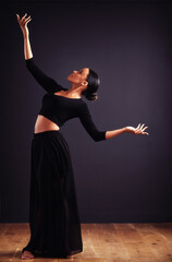 A feel for the theatrical. Female contemporary dancer in a dramatic pose against dark background.