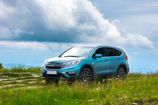 perechyn, ukraine - JUN 22, 2019: modern suv on a grassy meadow in mountains. reliable family vehicle for outdoor adventures. stormy weather with dark clouds on the sky