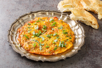Popular Indian Nepali Style Masala Omelette recipe served on plate on the table. Horizontal