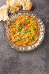 Indian food recipes Masala Omelette with fresh vegetables close up in the plate on the table. Vertical top view from above