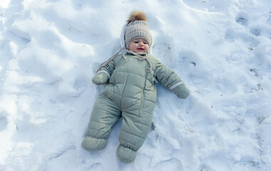 Fototapeta na wymiar child in winter, the child laying on the snow