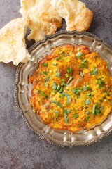 Masala Omelette Indian Style famous street food of Mumbai close up in the plate on the table. Vertical top view from above