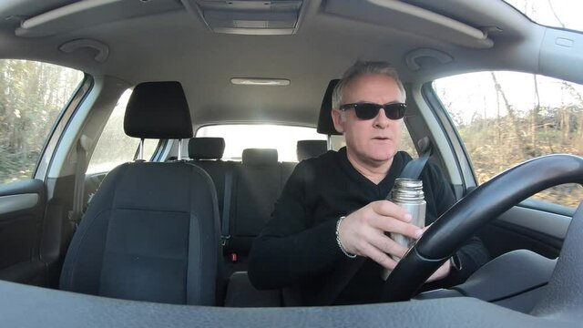 White man on road trip drinking water from thermos. Thirsty car driver sipping soda out of vacuum flask. People and beverage during travel