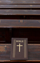 The holy Bible on the table of a prayer bench in the church.