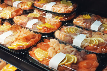 Snacks in supermarket. Shrimps and salted red fish.
