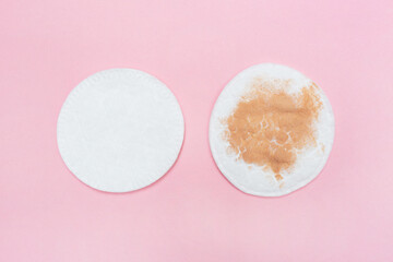 Two cotton pads for makeup dirty and clean on a pink background. Dirty and clean cosmetic pad after removing make-up. Hygiene concept
