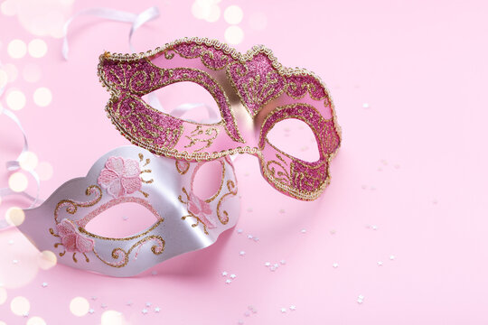 Carnival mask and confetti on pink background, festive flat lay copy space, pastel clors