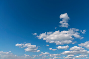 bright blue sky with group of white cumulus clouds as a natural background