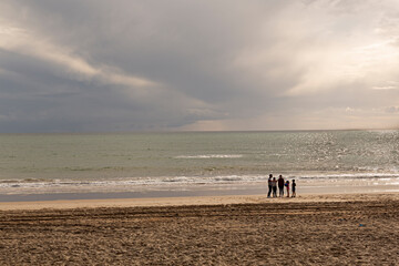 Familia en la playa al atardecer en un d&iacute;a de oto&ntilde;o.
