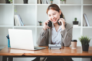 asian girl happy and charming Wear headphones to communicate by video conferencing at your desk. Using a laptop computer, video chat