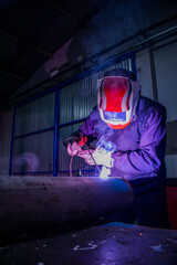 welder operator, welding with electric arc welder and white mask