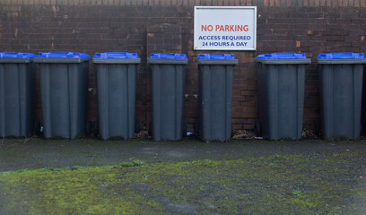 wheelie bins placed neatly side by side