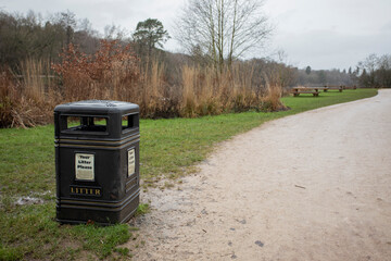 black litter bin by the side of a path in a local beauty spot