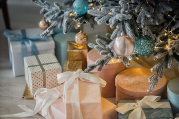 Beautiful Christmas gift boxes on floor near christmas tree in room