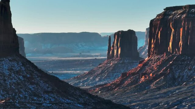 Scenic western landscape with parallax effect of steep rocky cliffs moving behind on motion blurry background. Monument valley cinematic nature on early morning with sunrise light on red mountains USA