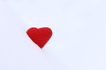 Red knitted heart in snow. Background for Valentine's card, romantic love