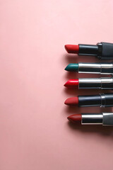 Lipsticks in various shades and colors on bright pink background. Top view. 