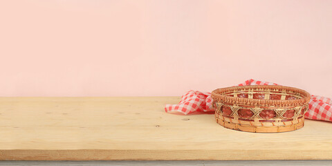 Empty basket with tablecloth on wooden table on old wall background, rustic style, eco concept,...