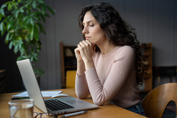 Young focused businesswoman working on laptop at office desk, female accountant looking at monitor...