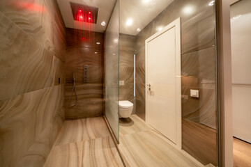 Shower and toilet near sink in contemporary bathroom designed in minimal style in apartment after...